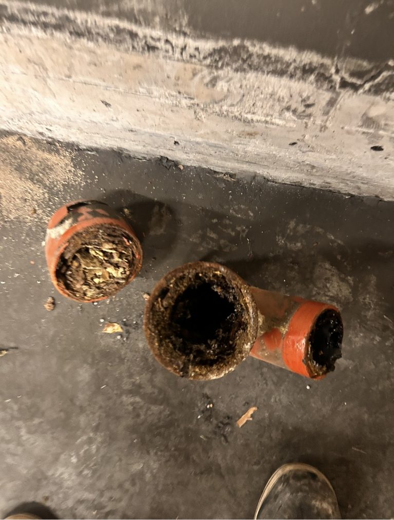 Drei ausgebaute Rohrstücke mit sichtbaren Ablagerungen im Inneren